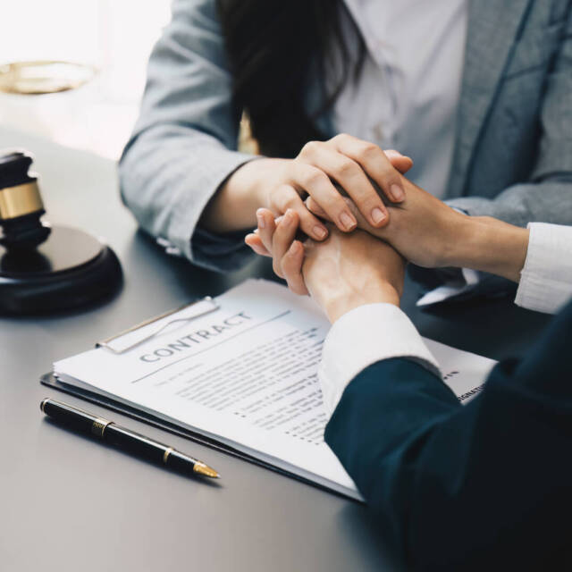 Lawyers holding business woman hand while consult at lawyer office. Law, legal services, advice, Justice and real estate concept.